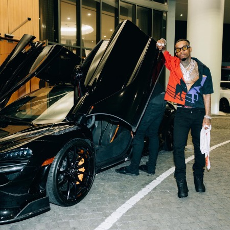 Tory Lanez posing with his luxurious car Mclaren. 